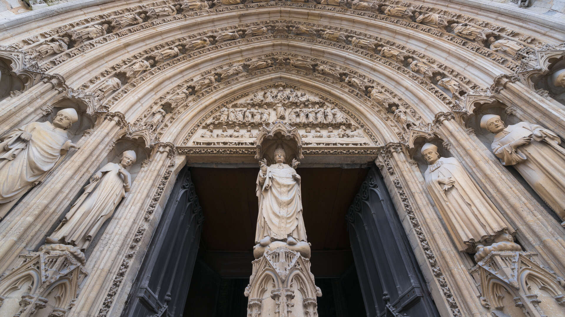 Portail gothique de la Cathédrale Saint-André de Bordeaux avec ses sculptures de saints en pierre et son tympan richement orné, montrant l'architecture religieuse médévale du XIIe siècle.