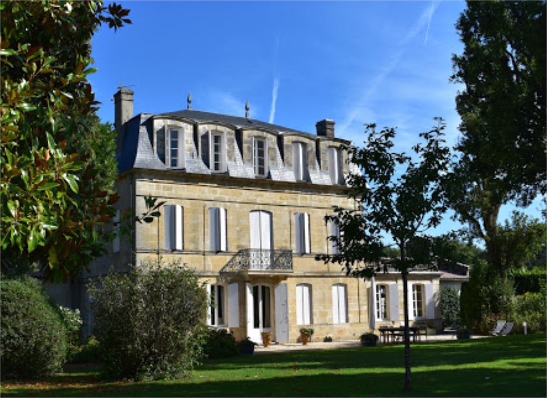 Élégante maison bourgeoise bordelaise du XIXe siècle avec façade en pierre blonde, toiture mansardée, entourée de jardins verdoyants