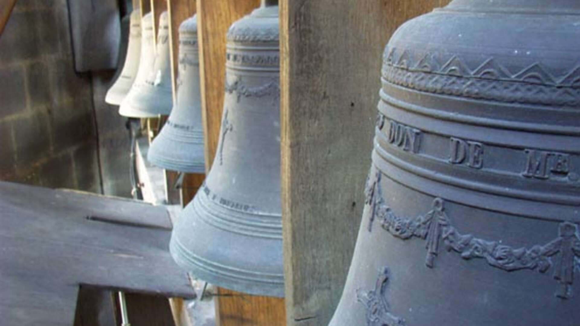 Détail des cloches de la Flèche Saint-Michel à Bordeaux, alignées verticalement avec leurs ornements en relief visibles