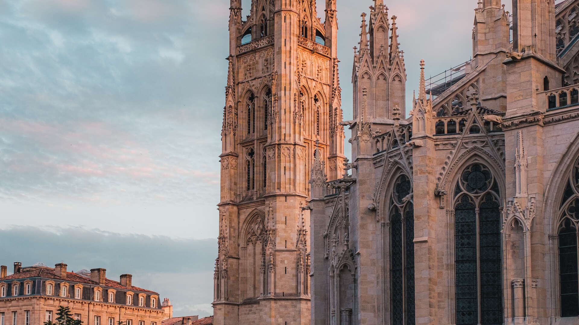 La Tour Pey Berland et la Cathédrale Saint-André de Bordeaux, édifices gothiques en pierre dorée avec détails architecturaux ornementés, photographiés au coucher du soleil.