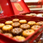 Boîte rouge ouverte contenant des canelés bordelais dorés saupoudrés de sucre, produit français traditionnel de Bordeaux