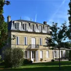 Élégante maison bourgeoise bordelaise du XIXe siècle avec façade en pierre blonde, toiture mansardée, entourée de jardins verdoyants