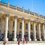 Le Grand Théâtre de Bordeaux, bâtiment néoclassique aux façades en pierre de taille avec colonnes corinthiennes blanches, situé en centre-ville de Bordeaux.