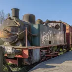 Locomotive à vapeur ancienne avec tender et wagon de marchandises rouille, exposée dans un parc à Bordeaux