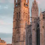 La Tour Pey Berland et la Cathédrale Saint-André de Bordeaux, édifices gothiques en pierre dorée avec détails architecturaux ornementés, photographiés au coucher du soleil.