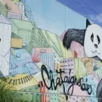 Fresque murale colorée à Bordeaux représentant des visages stylisés, des motifs géométriques et du texte artistique sur un bâtiment urbain.