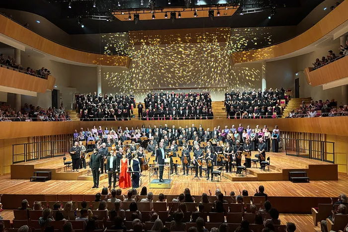 Concert du chœur symphonique Viva Vivaldi à Bordeaux dans une grande salle de concert avec orchestre et chanteurs sur scène, public en balcon et parterre.