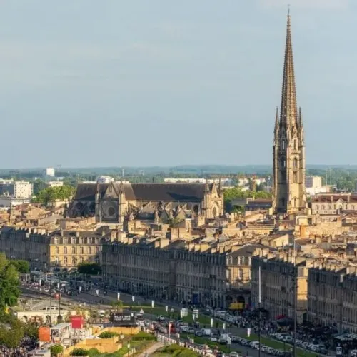 Vue aérienne de Bordeaux montrant la Flèche Saint-Michel dominant le centre-ville historique avec ses bâtiments en pierre de taille et ses toits mansardés.