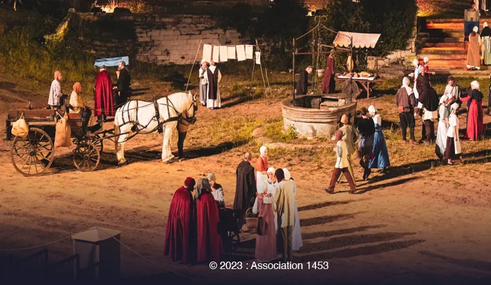Reconstitution historique de la Bataille de Castillon à Bordeaux montrant des personnages en costumes médiévaux dans un campement avec tentes, chevaux et activités quotidiennes du 15e siècle.