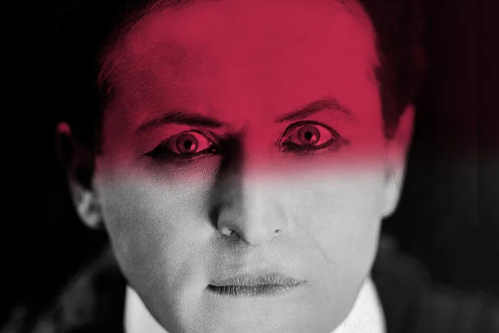 Portrait stylisé d'un homme en costume avec un éclairage rose dramatique, inspiré de l'opéra Macbeth présenté à Bordeaux