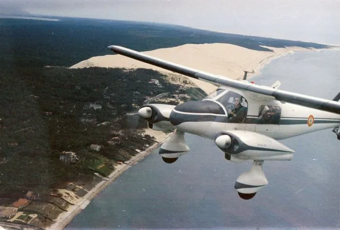 Vue aérienne depuis un avion de patrouille douanière survolant la côte atlantique avec dunes de sable et forêt littorale