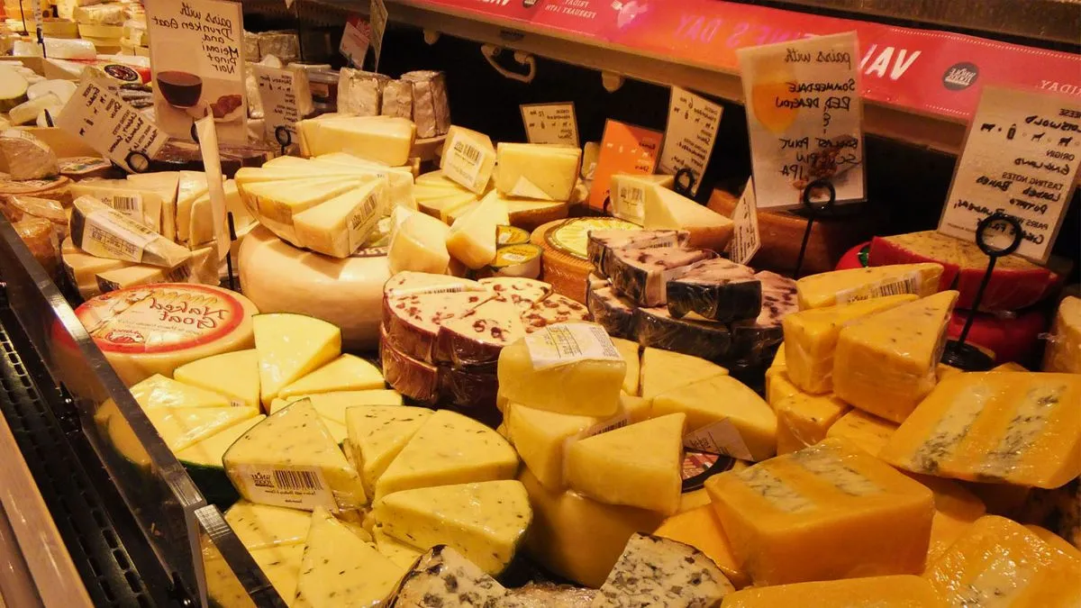 Étalage de fromagerie à Bordeaux présentant une variété de fromages français affinés, certains avec croûte naturelle ou lavée, étiquetés et disposés sur des présentoirs réfrigérés.