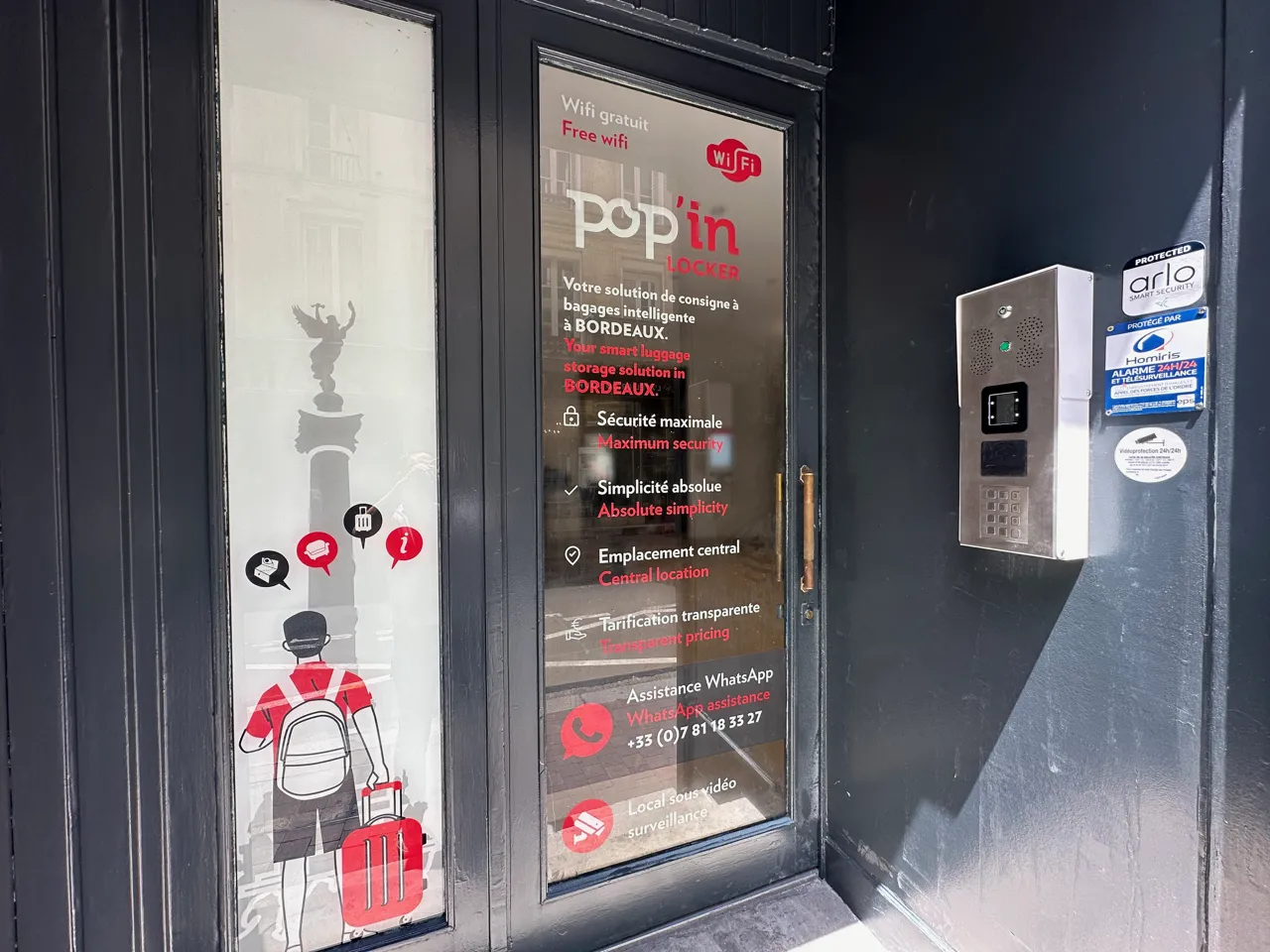 Devanture du service de casiers intelligents Popin Locker à Bordeaux avec affichage des caractéristiques du service : wifi gratuit, sécurité maximale, simplicité absolue, emplacement central, tarification transparente et assistance WhatsApp. Un automate d