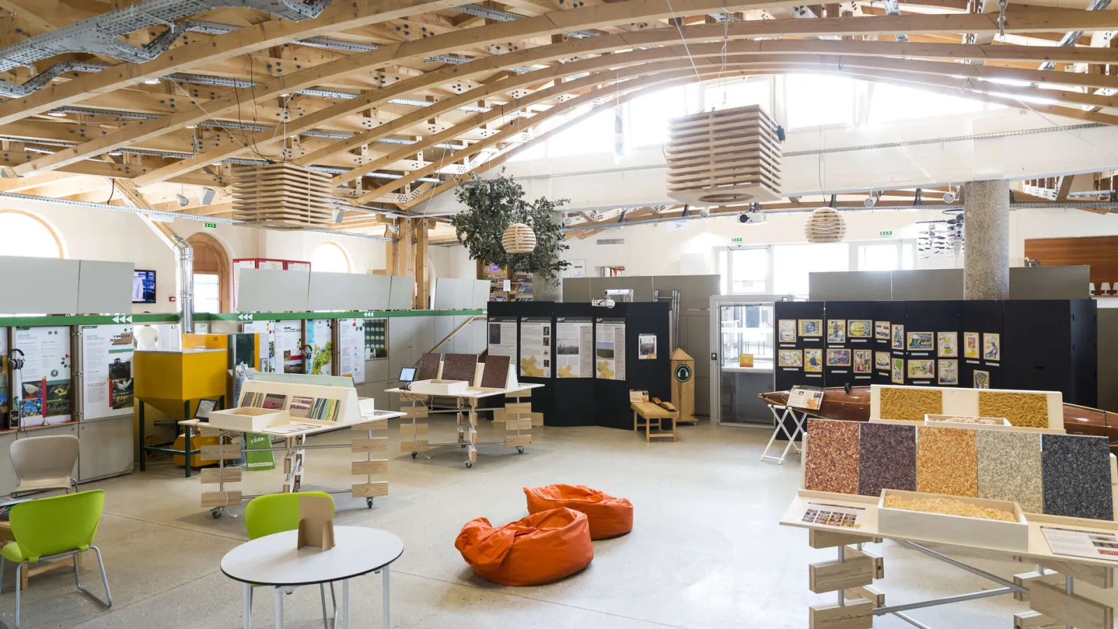 Intérieur spacieux de la Maison écocitoyenne de Bordeaux avec exposition sur les matériaux de construction durables, mobilier écologique et installations pédagogiques sur l'environnement