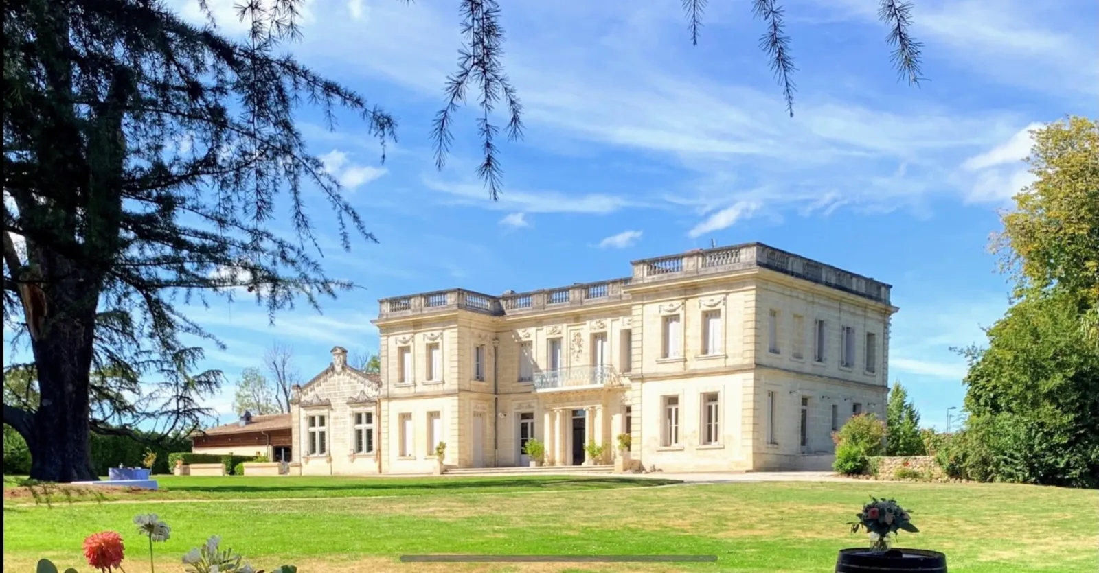 Château La Chèze à Bordeaux, élégante demeure de style néoclassique aux façades de pierre blanche, entourée de verdure et d'arbres centenaires.