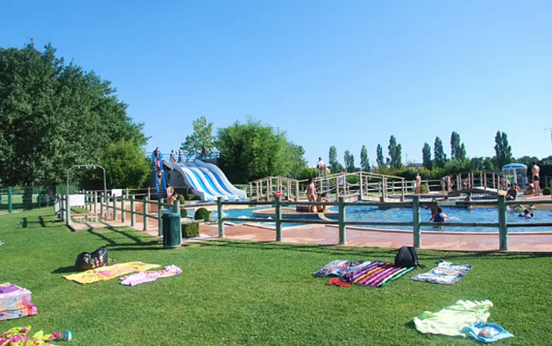 Piscine du Pinsan à Eysines près de Bordeaux avec bassins, toboggans bleus, aire de jeux aquatiques, espaces verts et visiteurs profitant des installations par beau temps.