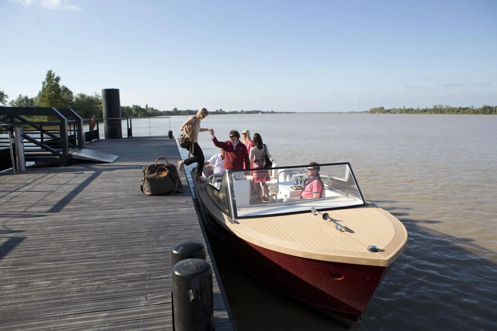 Passagers montant à bord du bateau taxi Grattequina au débarcadère de Bordeaux, avec vue sur la Garonne et les quais en arrière-plan