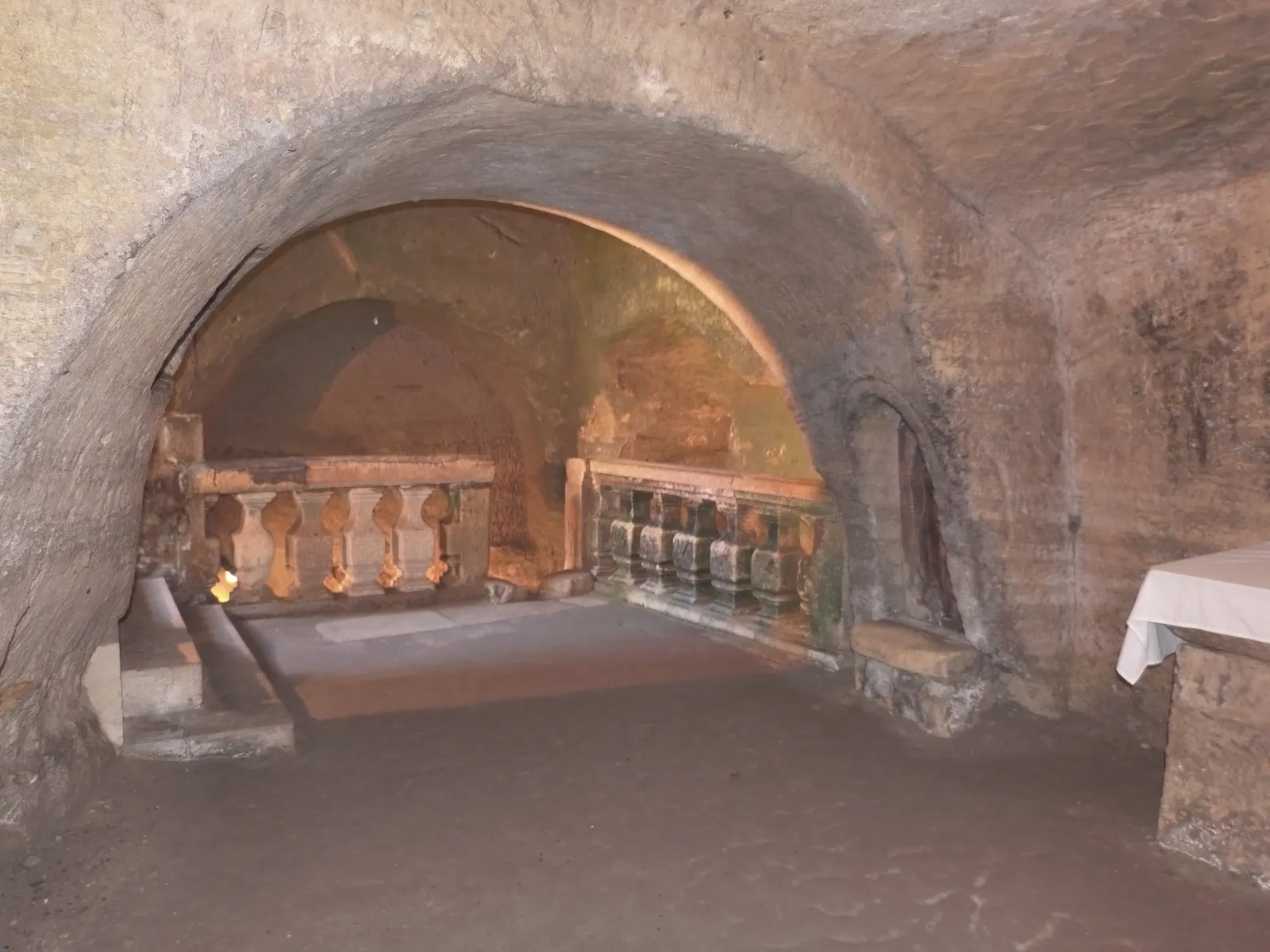 Voûte en arc de pierre d'une galerie intérieure du Château Laniote à Bordeaux, avec balustrades en pierre visible à travers l'ouverture et murs en pierre de taille.