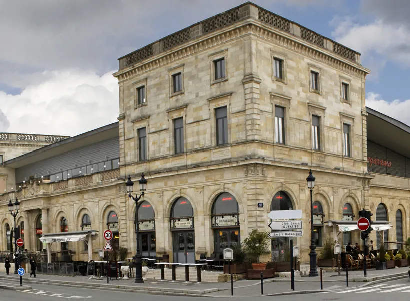 Façade du cinéma Mégarama Bordeaux Bastide, bâtiment historique en pierre de taille avec arcades au rez-de-chaussée et étages supérieurs à Bordeaux