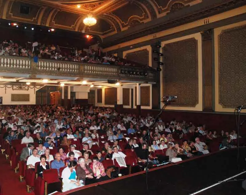 Intérieur d'une salle de théâtre historique de Bordeaux avec balcons dorés, plafond orné et public assis dans les fauteuils rouges
