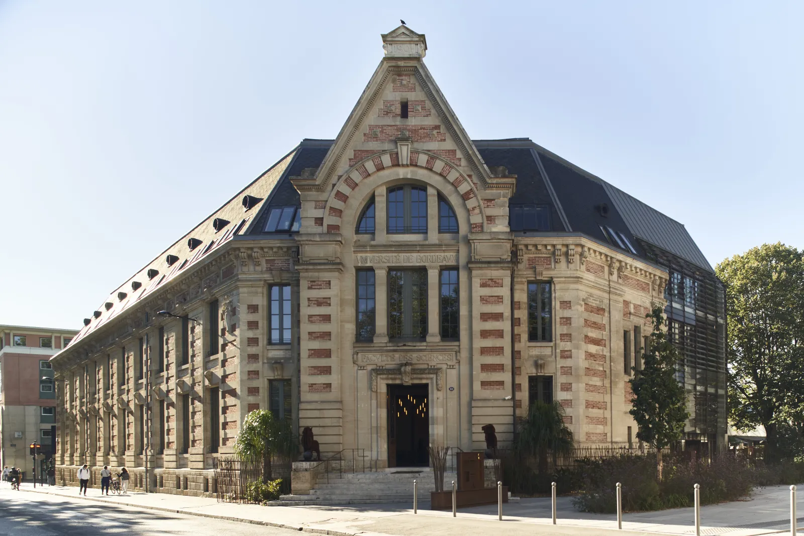 Façade de l'Hôtel La Zoologie à Bordeaux, bâtiment historique en pierre de style Beaux-Arts avec toit mansardé, grandes fenêtres en arc et tour centrale pointue.
