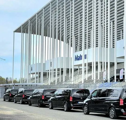 Flotte de véhicules noirs de luxe alignés devant le stade Matmut de Bordeaux, service de transport premium.