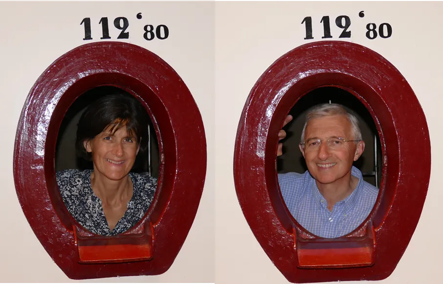 Deux portraits photographiques d'un homme et d'une femme encadrés dans des cadres ovales rouges numérotés 112°80, exposés au Château Laniote à Bordeaux.