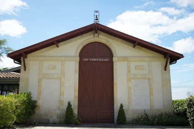 Petit bâtiment blanc et beige avec toit brun foncé et grande porte marron arquée, inscrit « CHYON FIGEAC », situé à Bordeaux.