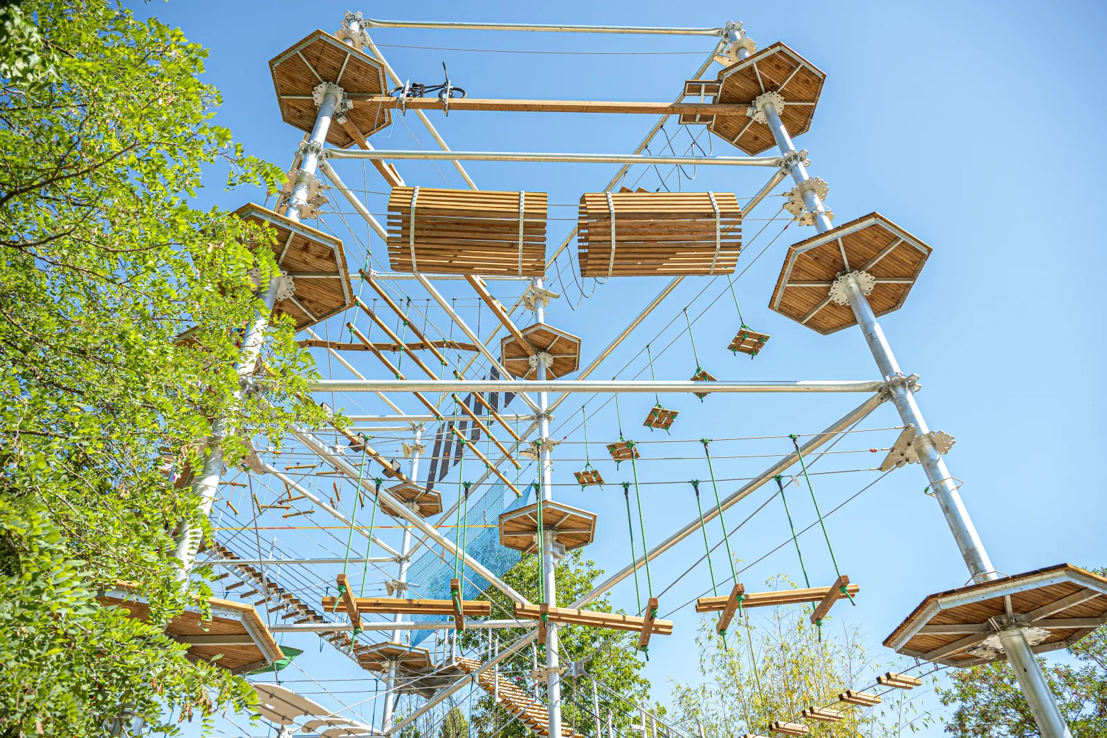 Parc d'aventure en hauteur avec parcours de cordes et plates-formes en bois suspendu entre les arbres, aux Cimes de Bordeaux à Pessac.
