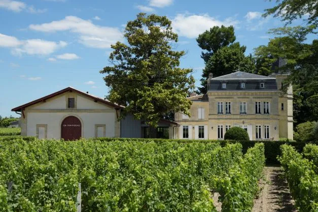 Château Yon-Figeac à Bordeaux avec ses bâtiments historiques entourés de vignobles en été