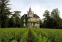 Château les Carmes Haut-Brion à Bordeaux, maison de maître du XIXe siècle avec toit mansardé entourée de vignobles et de verdure