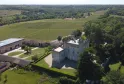 Vue aérienne du Château de Camarsac près de Bordeaux, forteresse blanche avec tours entourée de douves, de jardins verts et de vignobles dans la campagne girondine.