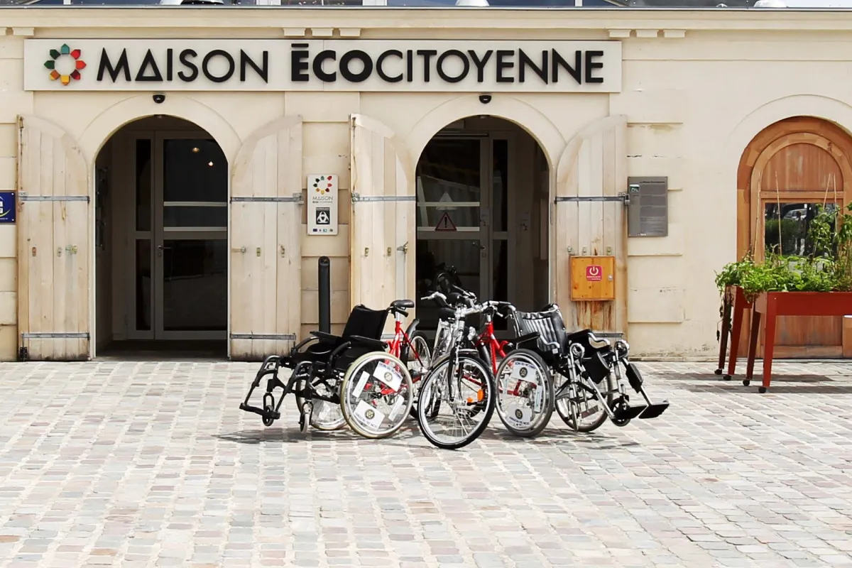 Façade de la Maison Écocitoyenne de Bordeaux avec plusieurs vélos garés devant l'entrée, illustrant l'accessibilité et les modes de transport durables.